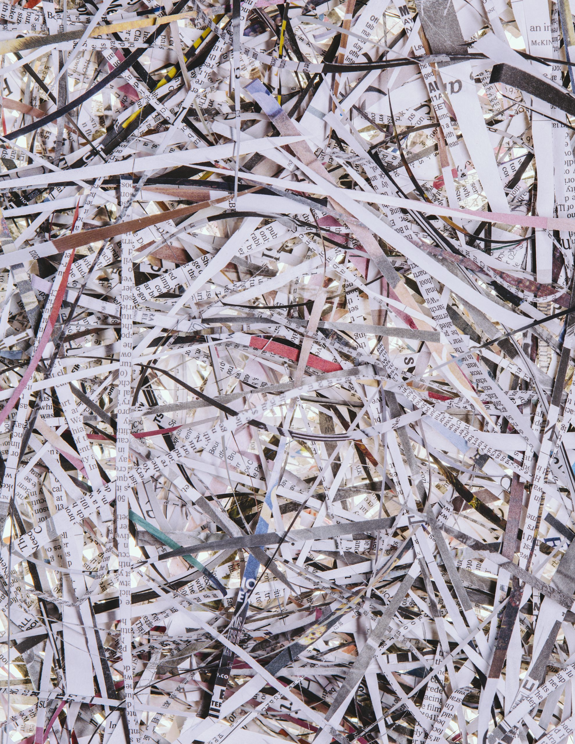 A pile of long thin shredded pieces of printed newspapers.